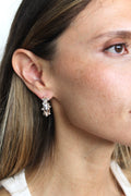 Close-up of a woman wearing a silver earring with a gemstone.